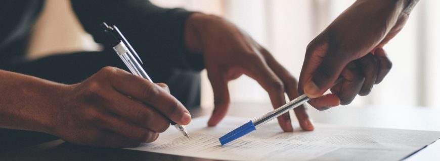 Cropped shot of an unrecognizable man filling a document with the help of a financial advisor at home